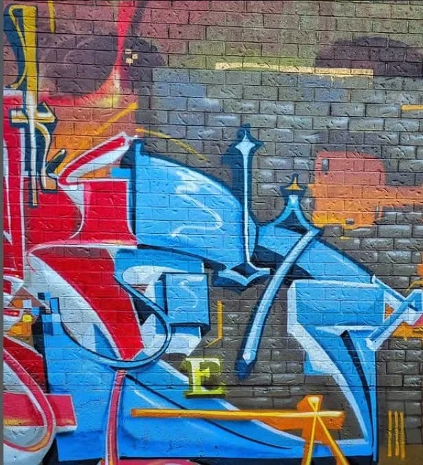 Fresque graffiti de Monk.E aux lettrages bleus et rouges.